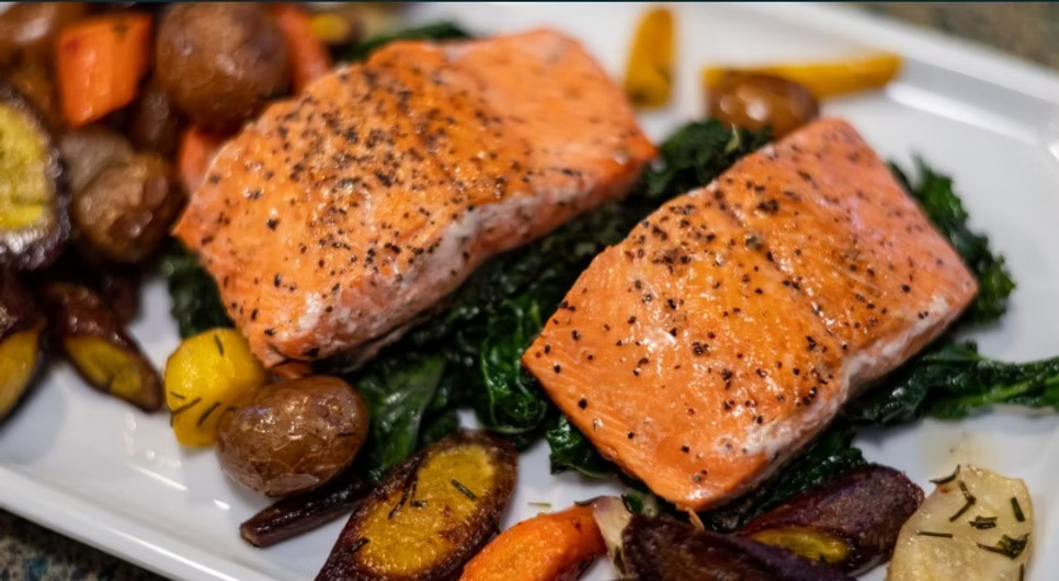Skillet Copper River sockeye salmon paired with potatos, carrots, onions, green beans, and mixed greens