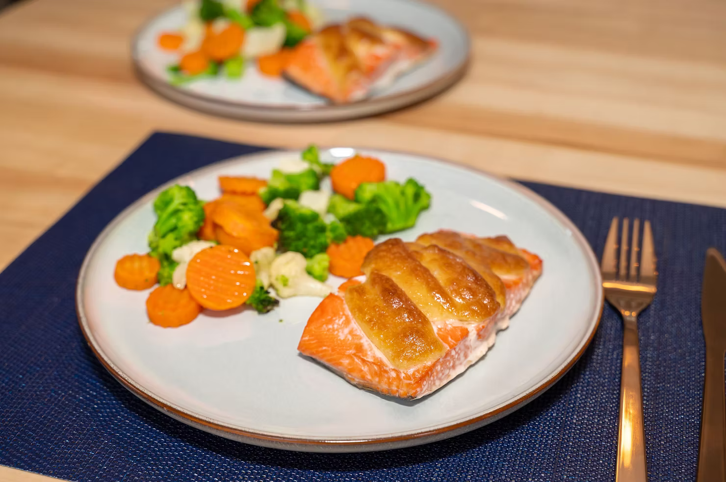 This image displays a Copper River Sockeye fillet topped with garlic aioli and roasted vegetables on the side.