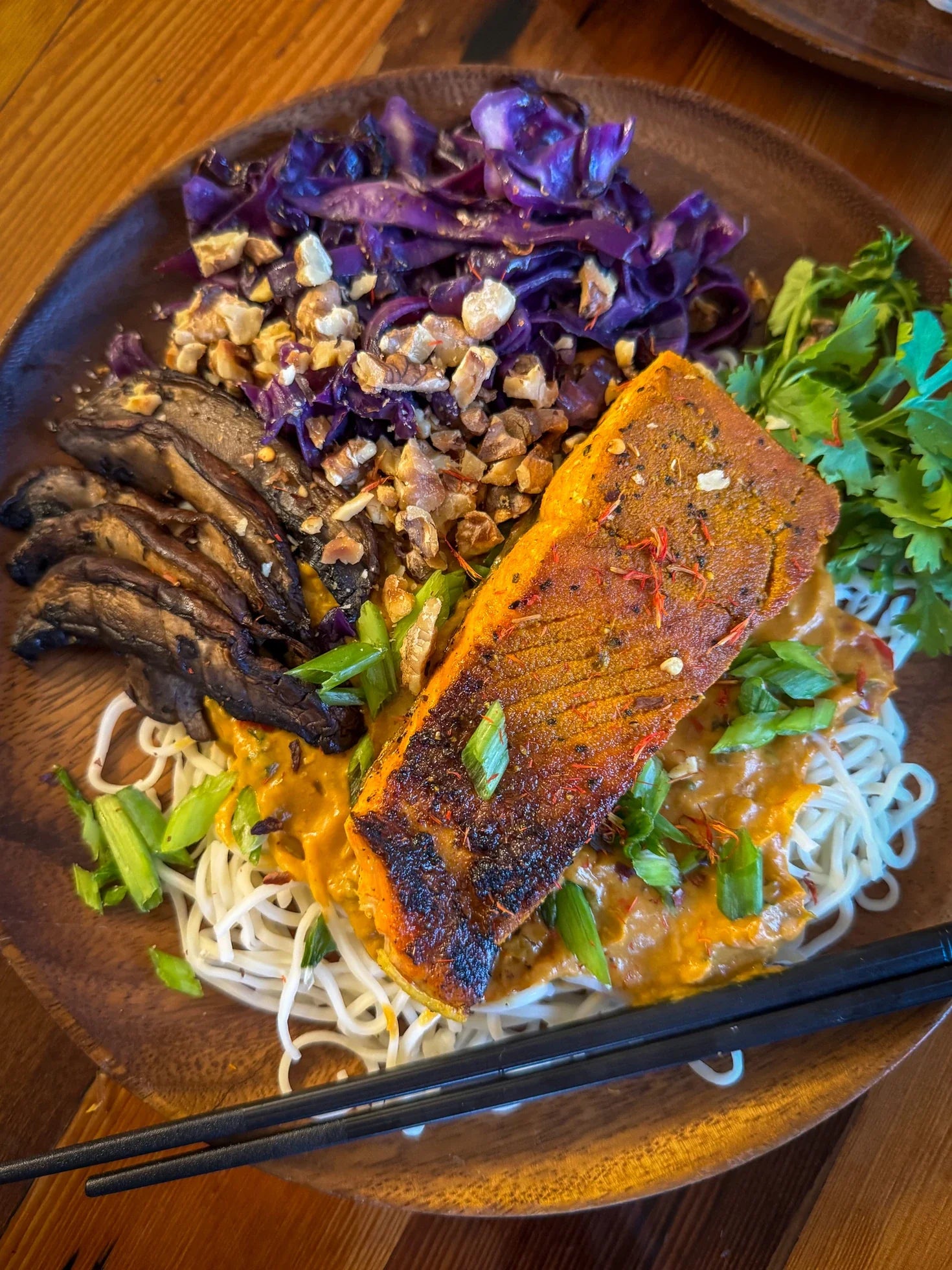 Pumpkin spiced salmon paired with curry, purple cabbage, mushrooms, green onions, and chili oil