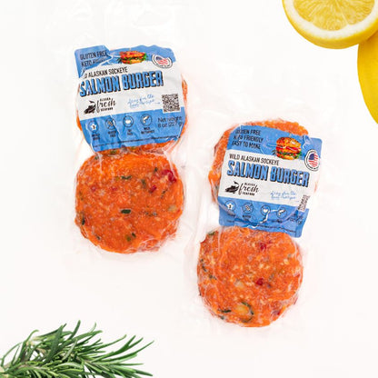 Two packages of salmon burgers with a lemon and rosemary on a white background